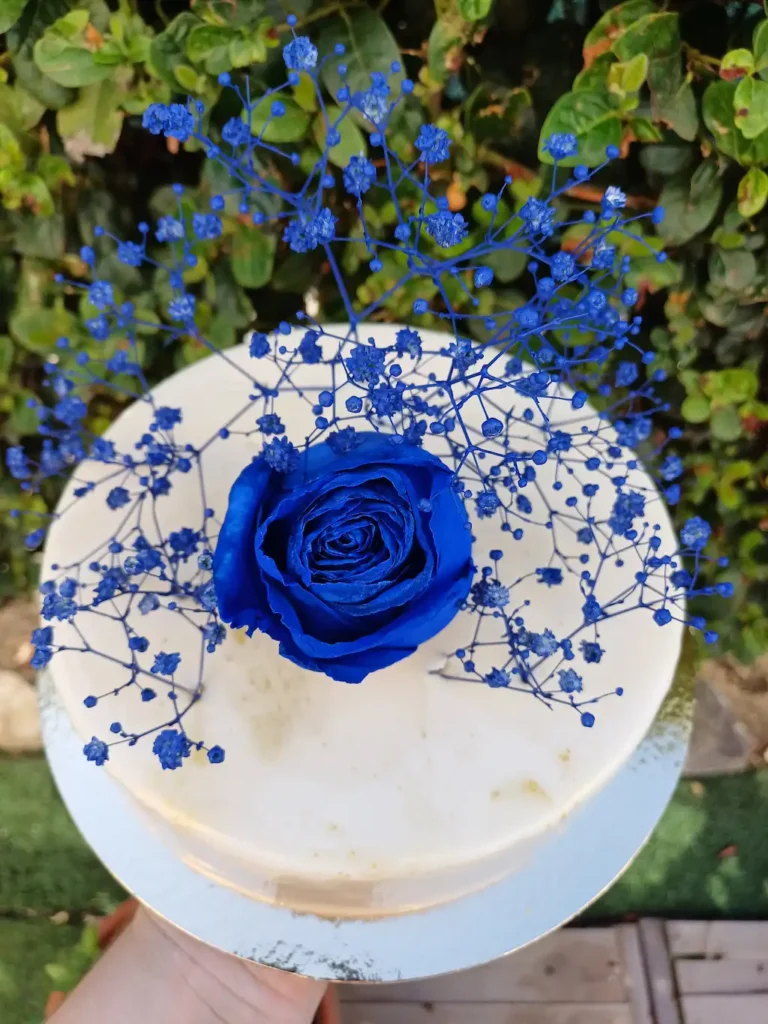 Entremet exotique glacée en blanc et fleur bleu
